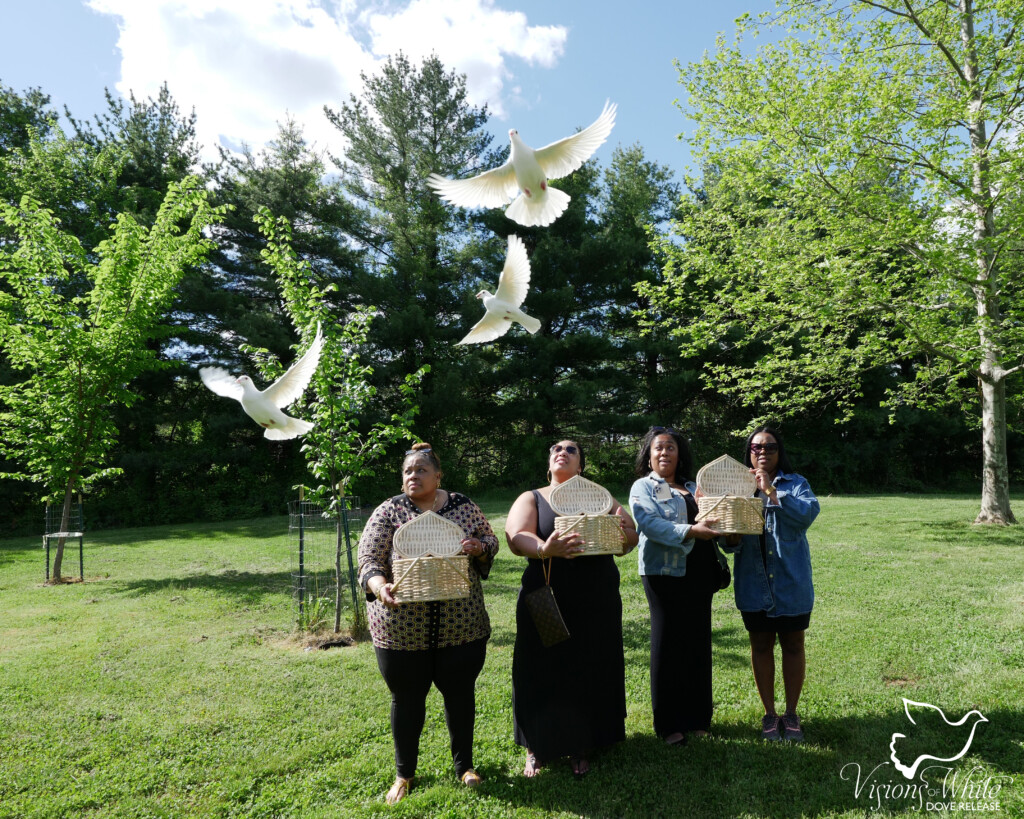 Four people releasing three white doves in Philadelphia, PA.